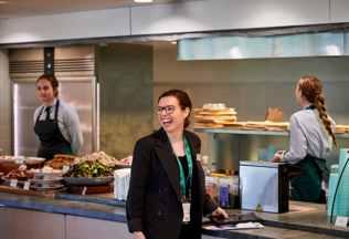A female member of Constellation's leadership team laughing in a kitchen at Wimbledon.